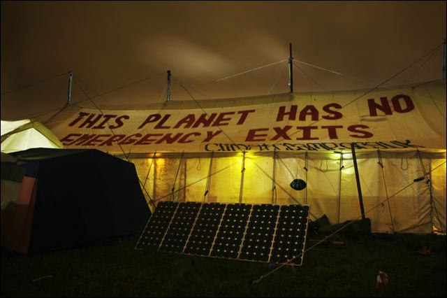 Climate camp main marquee at night - planet has no emergency exits banner