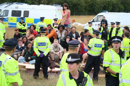 Climate campers sit on woodpile